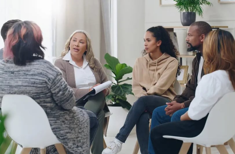 Multiple staff sitting in a mental wellness meeting