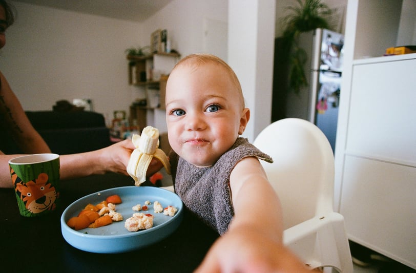 a baby is eating a banana in a bowl