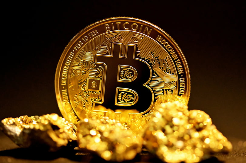 Moeda de Bitcoin dourada cercada por pepitas de ouro representando valor e escassez digital