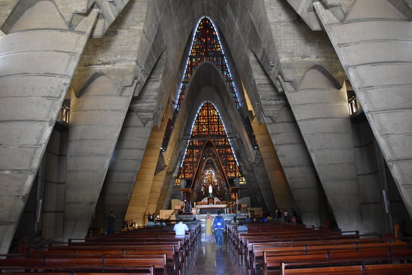 Interior view of Basílica de Higüey with stained glass and unique concrete arches