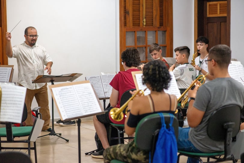 a man in a white shirt and a bandleader playing a trumpet