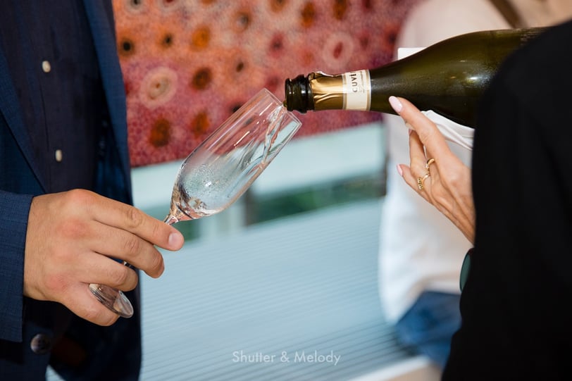 Eine Kellnerin schenkt Sekt in ein Glas ein.