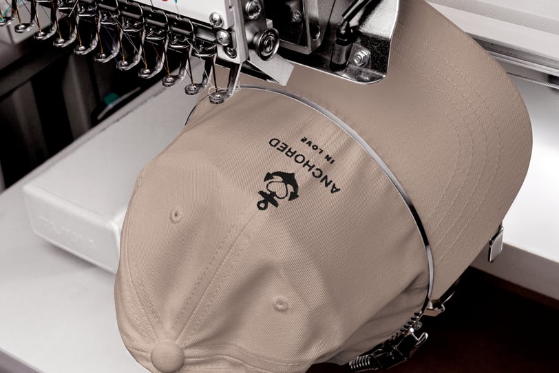 a beige cap being embroidered with anchor design