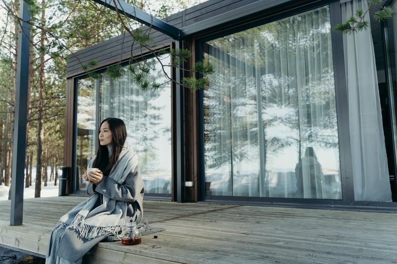 a woman sitting on a deck with a coffee cup