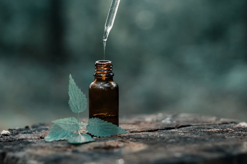 Frasco de aceite esencial con gotero sobre superficie natural, utilizado en sesiones de aromaterapia para aliviar estrés y an