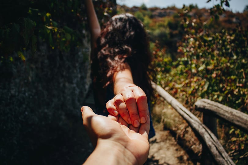 a guy holding a hand out to his girlfriend