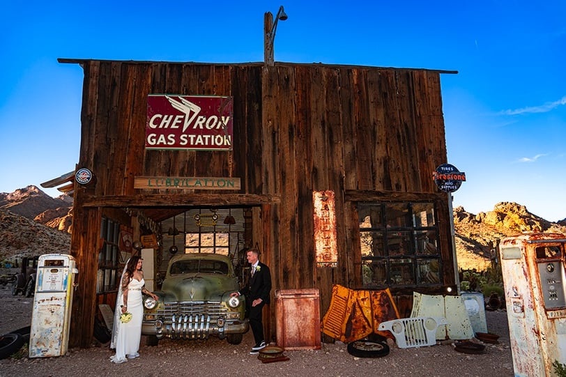 a man standing in front of a building with a car in front of it