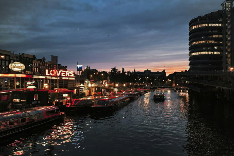 a river with boats and buildings in the background