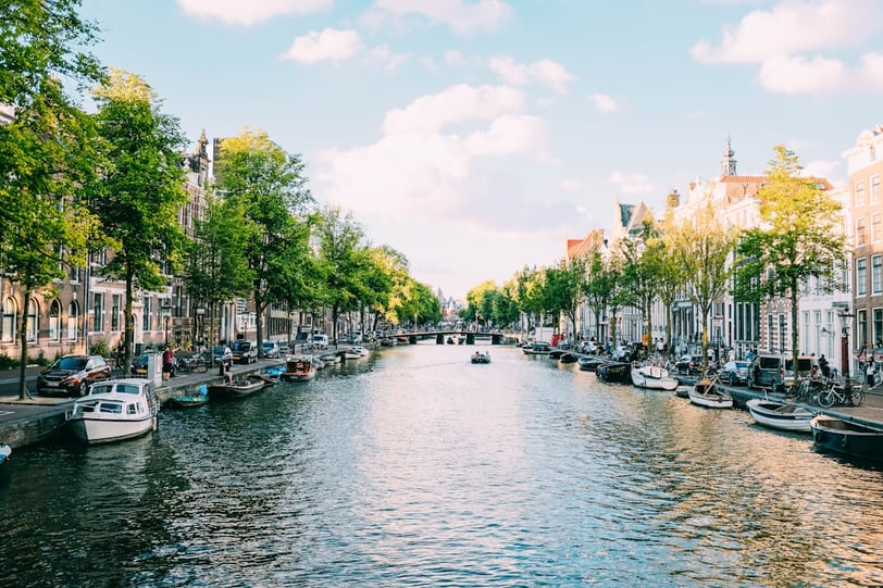 a canal with boats and people walking on it