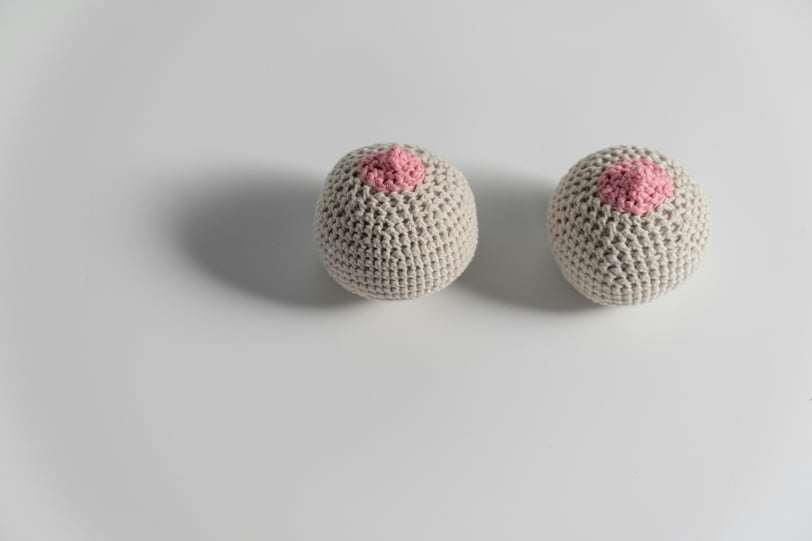 two crochet balls with pink on them