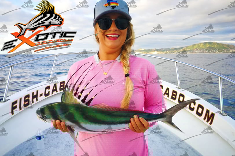 a woman in a pink shirt is holding a fish fish