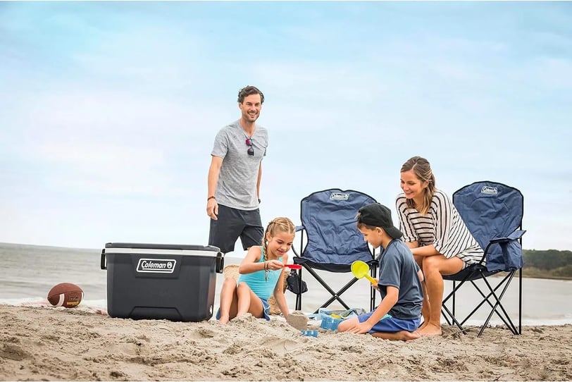 Una familia en la playa utilizando sus sillas Coleman