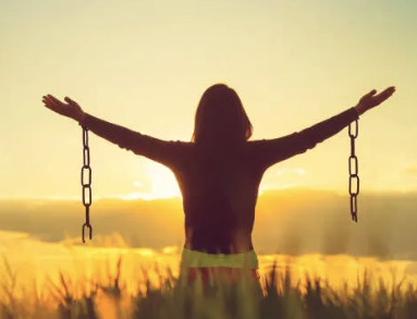 a woman standing in a field with her arms outstretched out and arms outstretched out