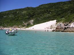 playa con un barco y gente