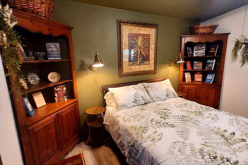 a bed room with a bed and a book shelf brass accents antique furniture