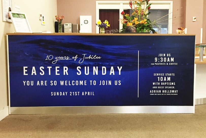 Reception desk at Jubilee Community Church wrapped with an Easter Sunday promotional design.