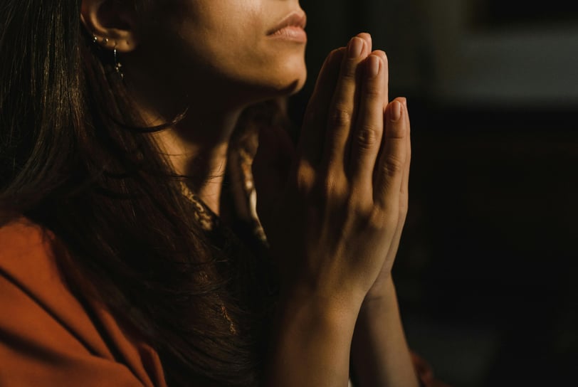 a woman in a red shirt is praying