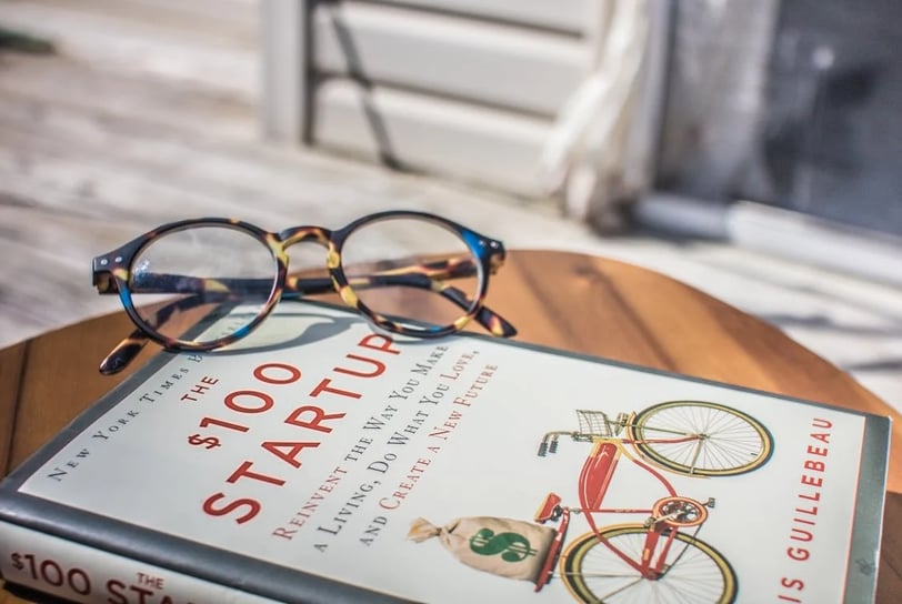 a book with glasses and a book on a table