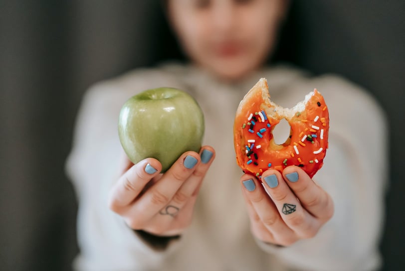 a woman holding a donut and a donut
