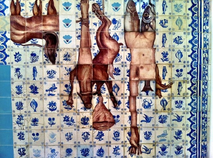 Mural com padrões de azulejos e fragmentos de carne.