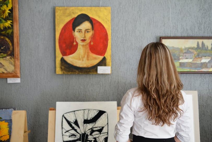 Mulher admirando uma pintura abstrata em uma galeria de arte moderna.