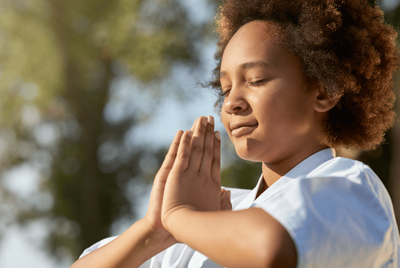 a woman in a white shirt is holding her hands together