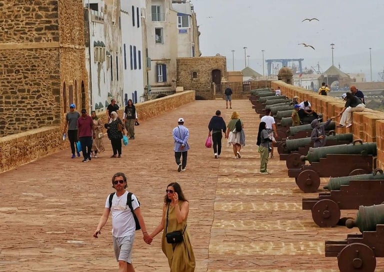 morocco a couple holding hands while walking down a path