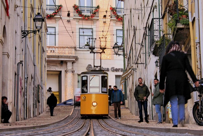 a trolley car on a narrow street in a city
