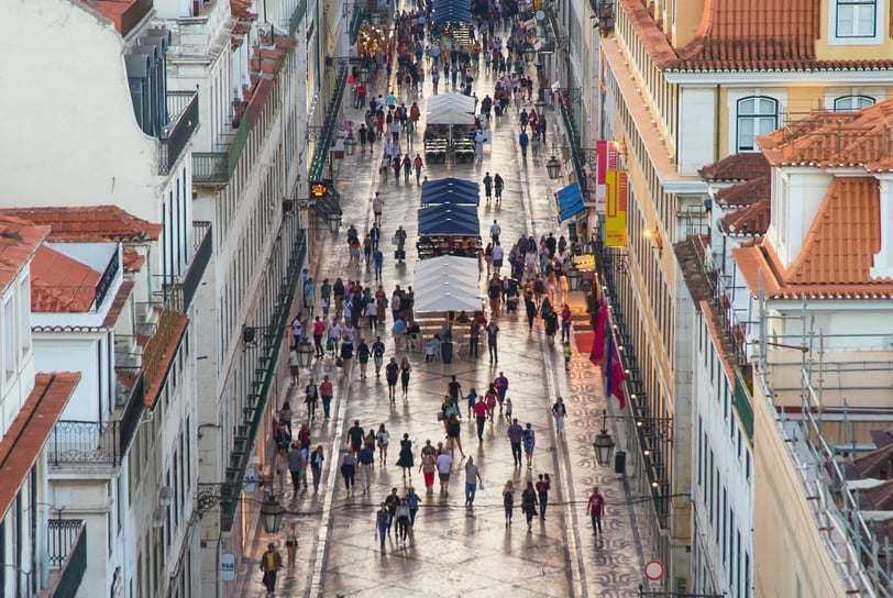 a city street scene with a horse drawn carriage and people walking down the street