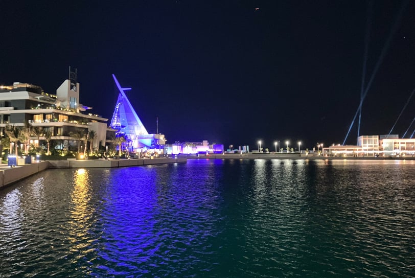 a boat in the water with a sailboat in Jeddah Corniche, Saudi Arabia