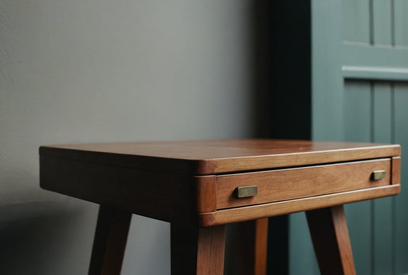 a small wooden table with a drawer