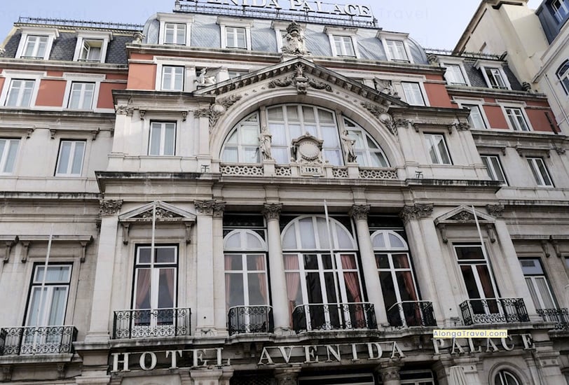 Gray Pombalin style building decorated with white columns, statues and plaster