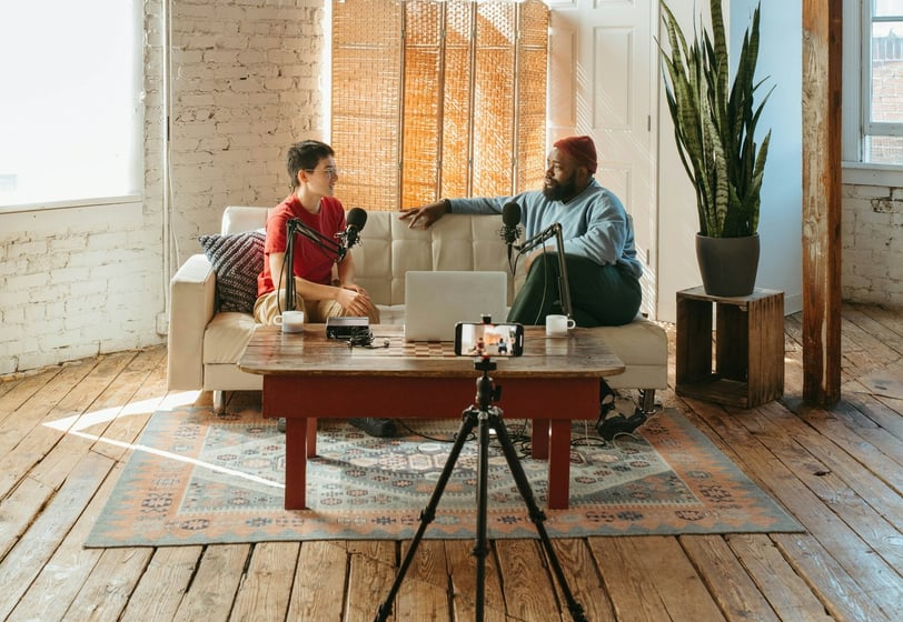 Video podcaster and guest sitting on a sofa
