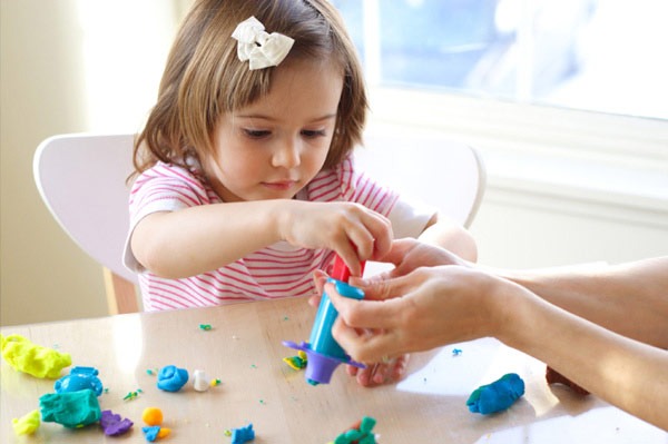 seorang anak kecil perempuan yang sedang bermain untuk melatih sensoriknya