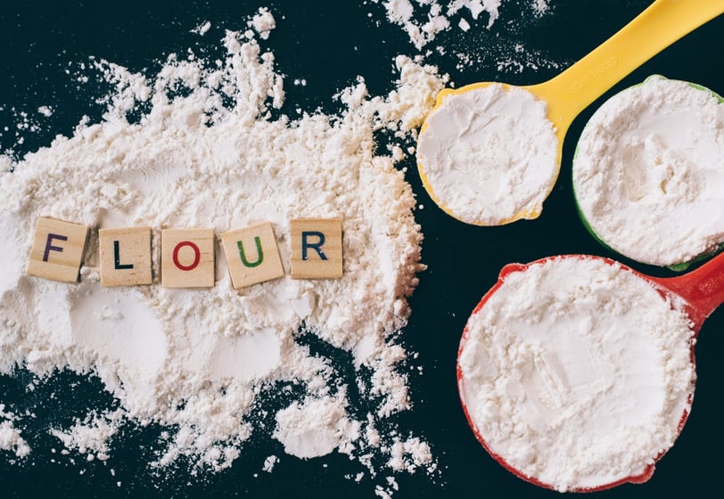 flour and measuring cups on a kitchen counter