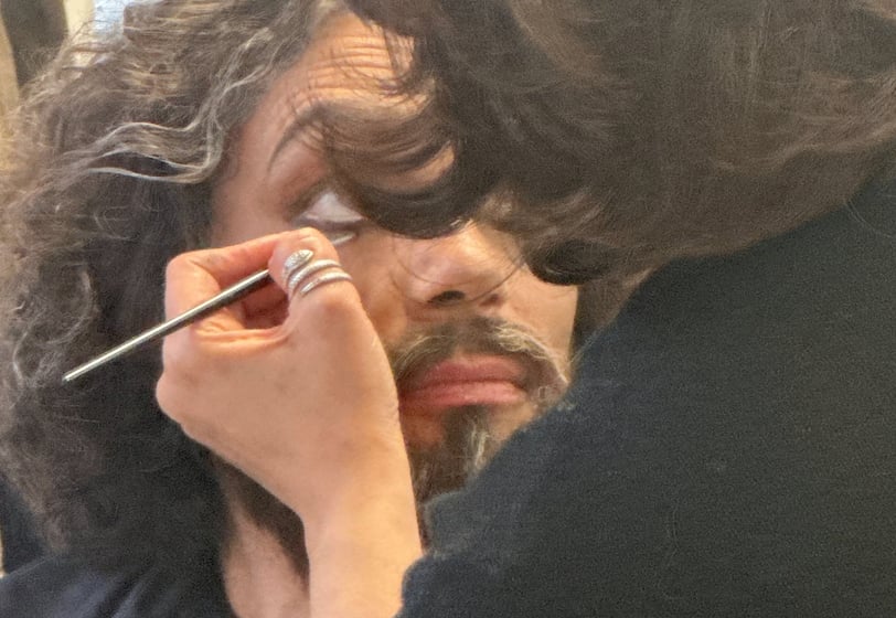a man with a mustache and a beard, getting his hair cut
