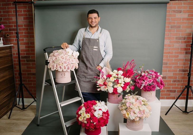 a man in a apron and aprons holding flowers