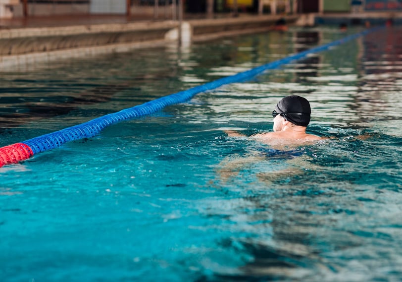 uomo che nuota in una piscina olimpionica