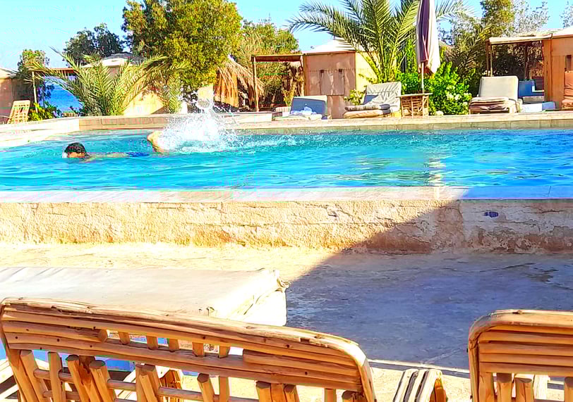Nen nedant a la piscina prop del mar i bungalow a l'estrella beduïna d'Egipte
