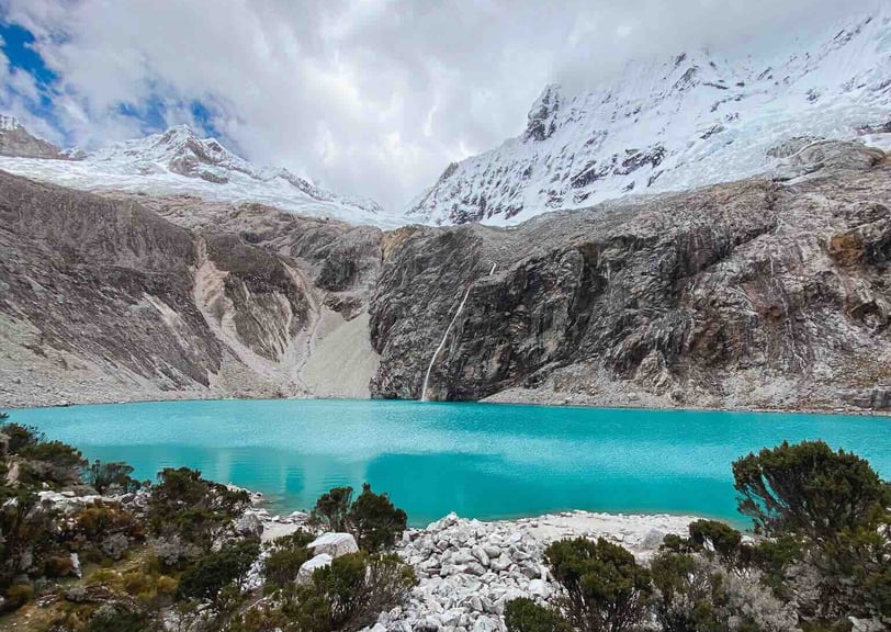 Breathtaking view of Laguna 69, with its vibrant turquoise waters and majestic glaciers in the Huaraz region of Peru.