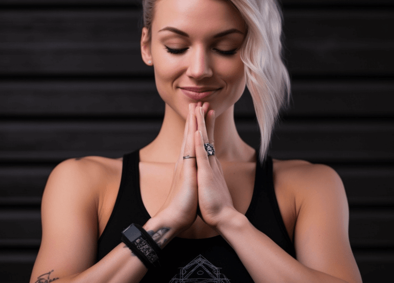 a woman with blonde hair and a black tank top meditating