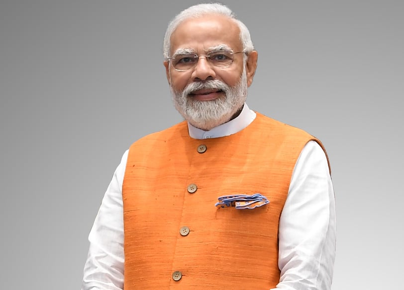 Narendra Modi in an orange vest and local dress
