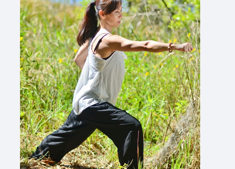 a woman in a white tank top and black pants