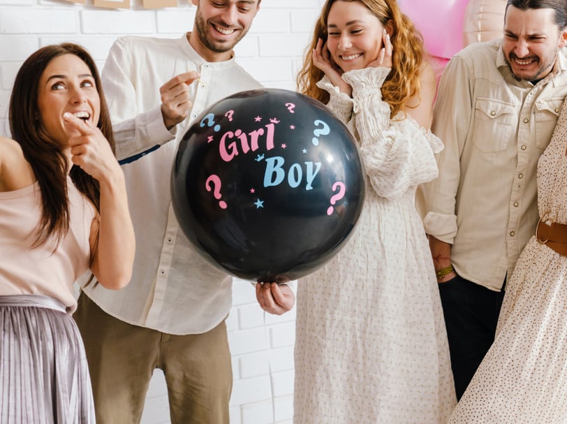 a group of people standing around a balloon - shaped balloon