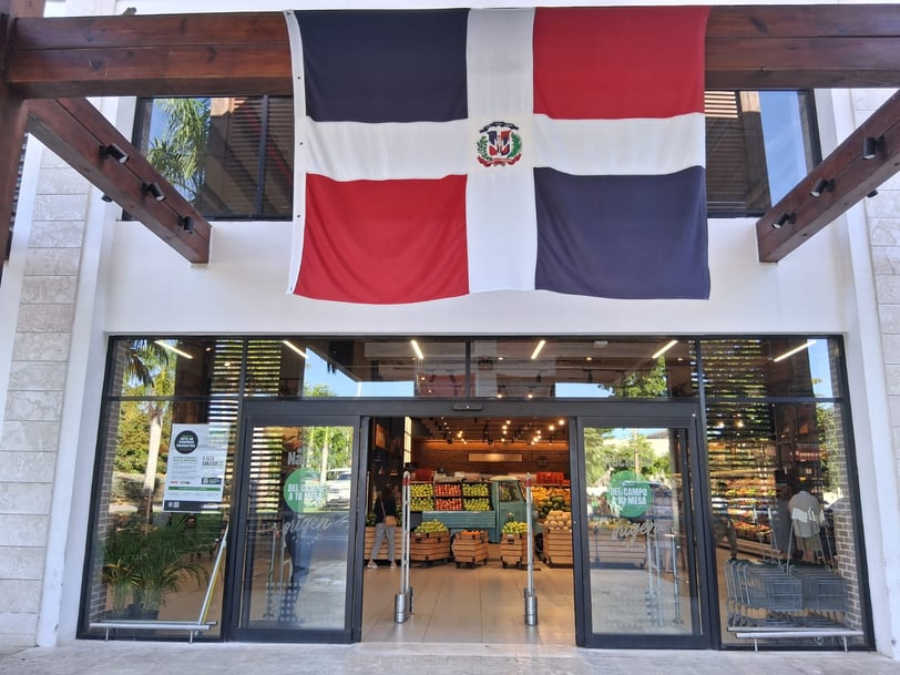 Dominican Republic supermarket entrance with fresh produce and national flag above the door 