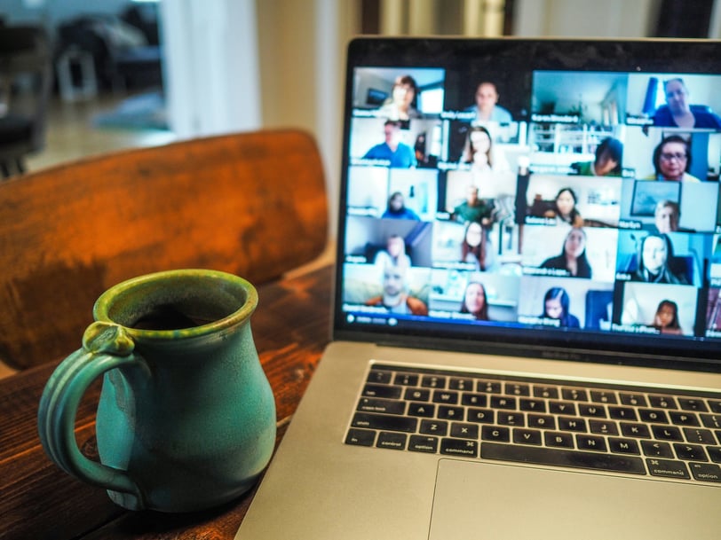 a laptop computer with a cup of coffee and a mug of coffee