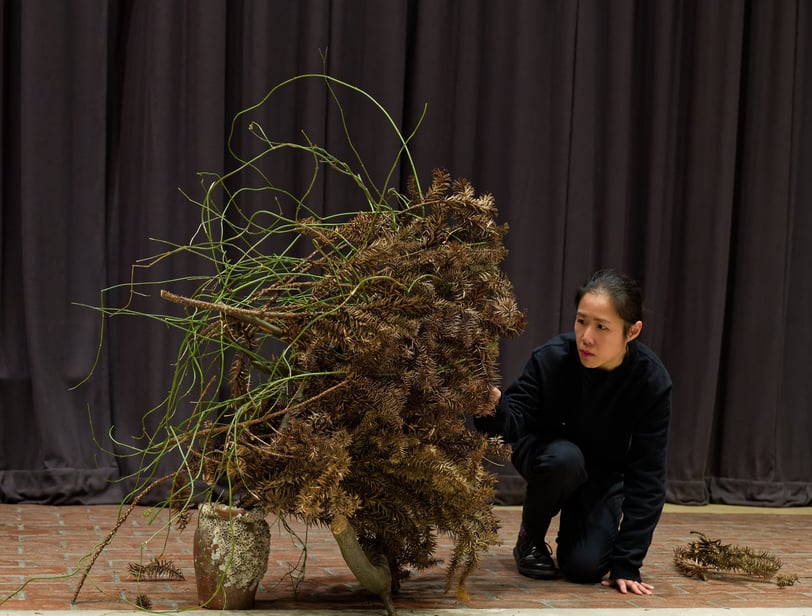 Hedy Leung performing Ikebana with dried green materials at The Wash Houses, London