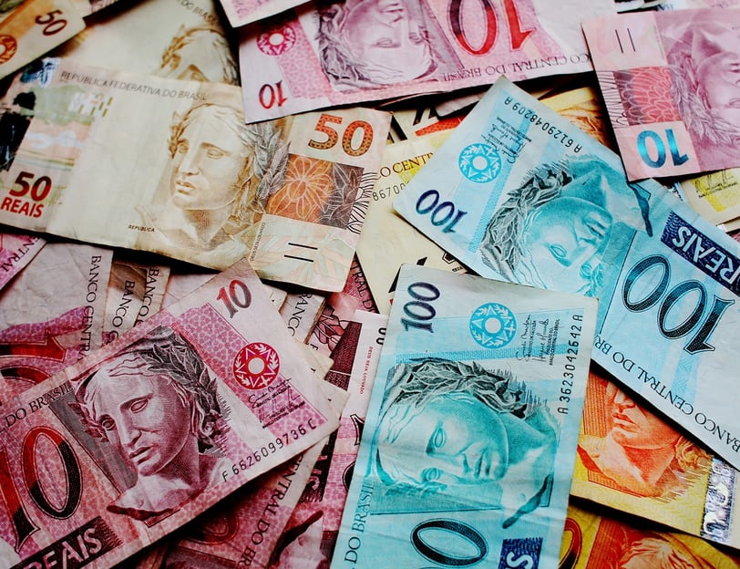 cédulas de reais em ci,a de uma mesa 