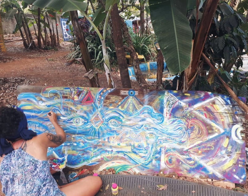 Naía en train de peindre sur une ancienne porte avec des tons de bleu