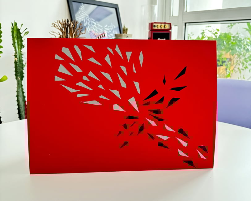 arte em fita isolante prata e preta sobre papel vermelho.